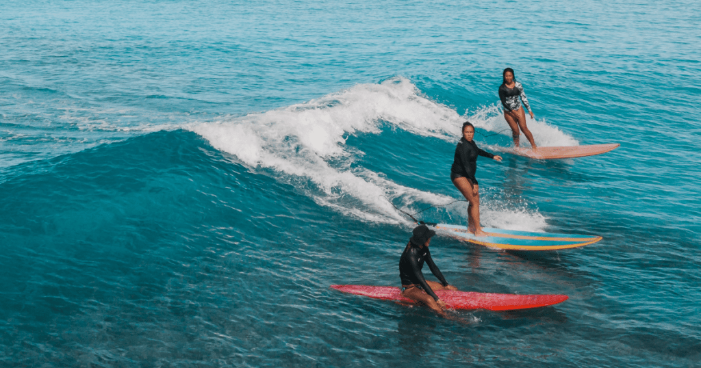A group of girls surfing at the beach